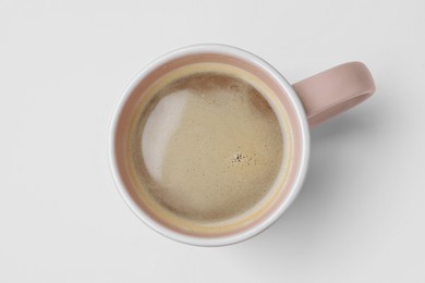 Photo of Mug of freshly brewed hot coffee on white background, top view