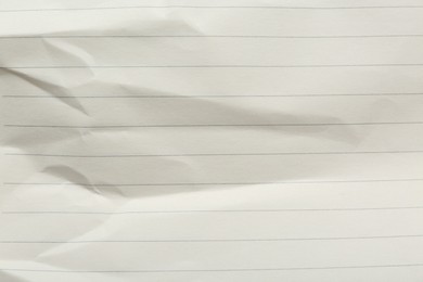 Photo of Crumpled lined notebook sheet as background, top view