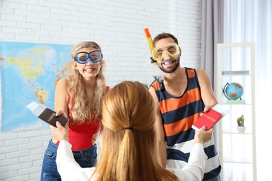 Beautiful young couple visiting travel agency office