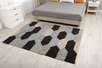 Stylish carpet with pattern on floor in bedroom