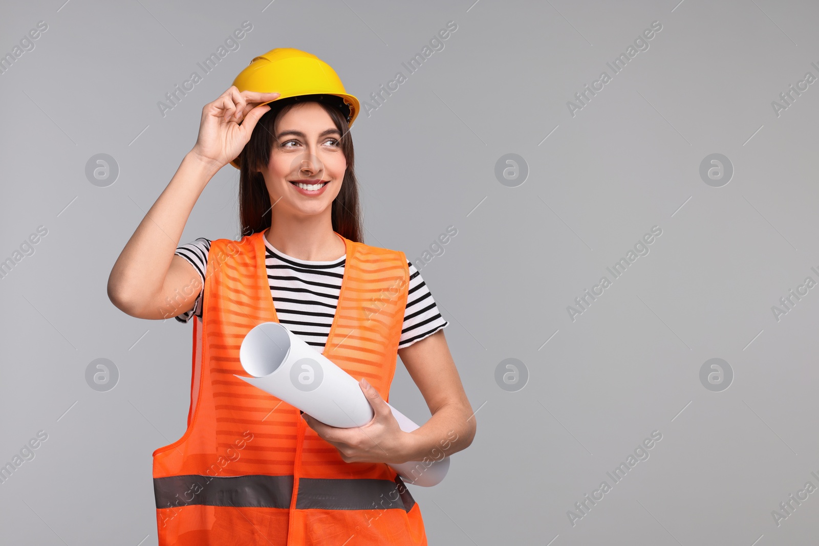 Photo of Architect in hard hat with draft on light grey background, space for text