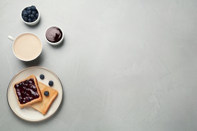 Toast with blueberry jam and cup of coffee served on table, flat lay. Space for text