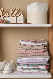 Photo of Baby clothes and accessories on wooden rack