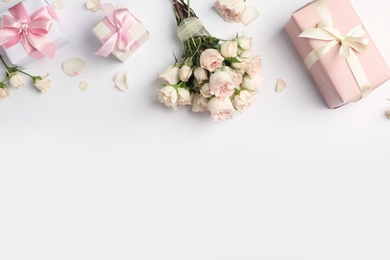 Photo of Flat lay composition with beautiful roses and gift boxes on white background. Space for text