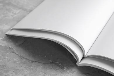 Photo of Blank open books on light grey marble background, closeup. Mock up for design