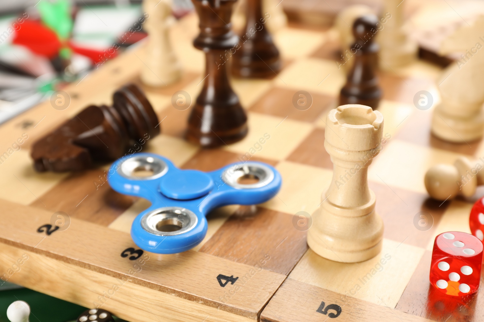 Photo of Spinner, pieces and dices on chess board, closeup. Tabletop games