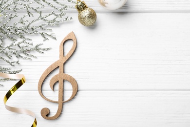 Photo of Flat lay composition with music note on white wooden background, space for text. Christmas celebration
