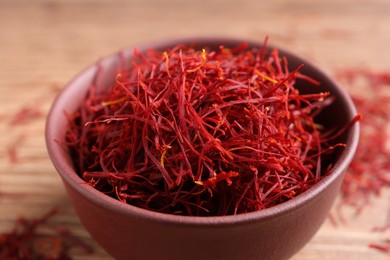 Photo of Dried saffron in bowl on table, closeup