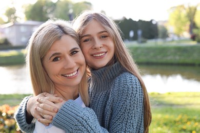 Photo of Happy mother with her daughter spending time together in park on sunny day