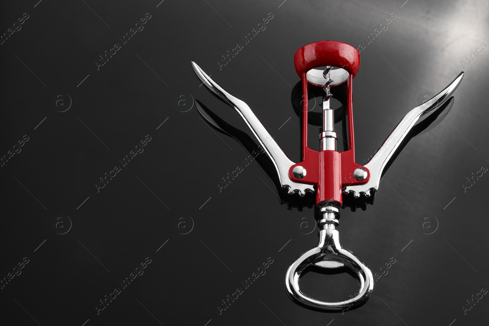 Photo of One wing corkscrew on grey table, above view. Space for text