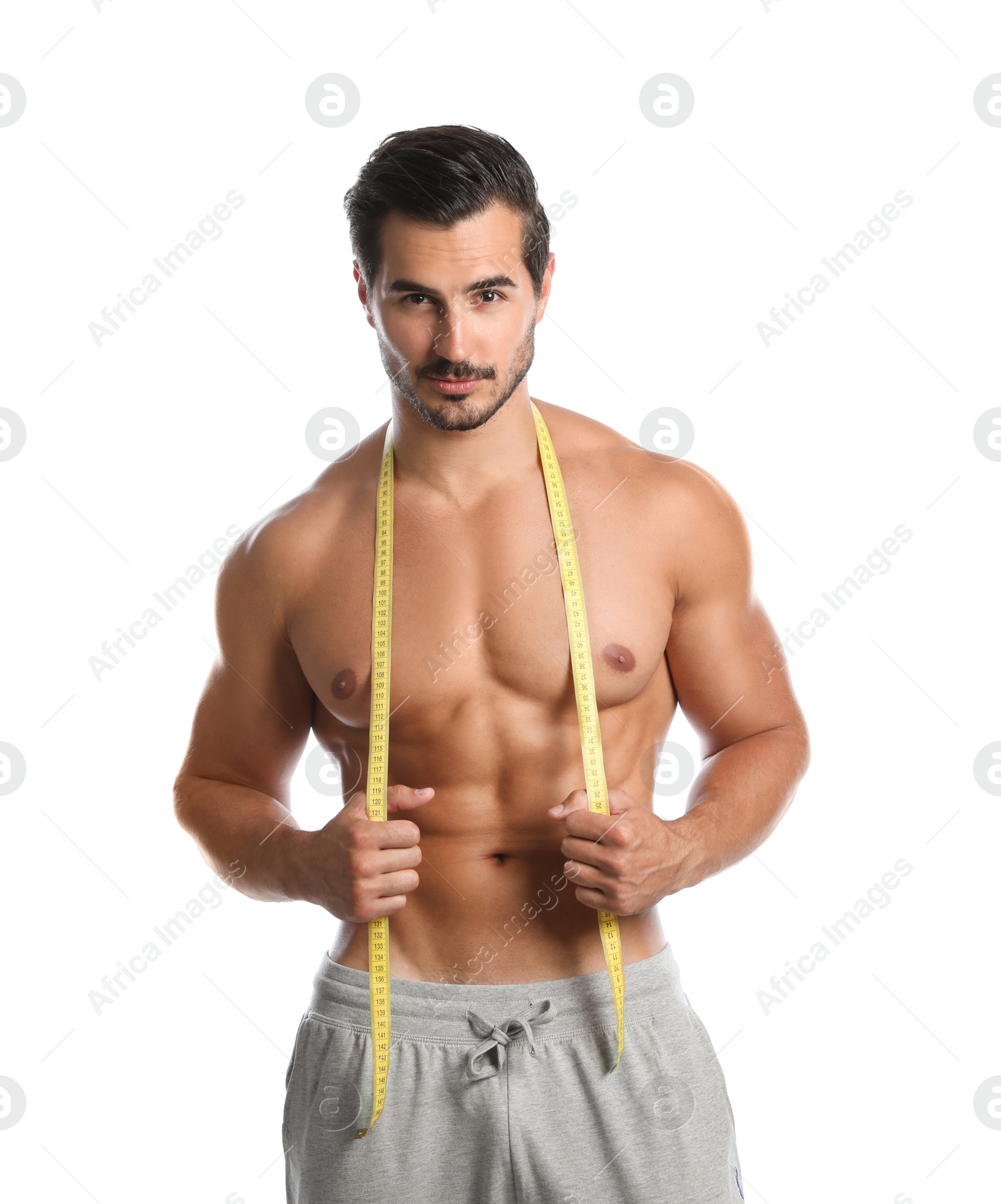 Photo of Young man with slim body using measuring tape on white background