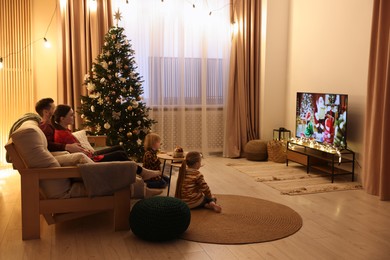Photo of Family watching TV in cosy room. Christmas atmosphere