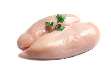 Raw chicken breasts with parsley on white background