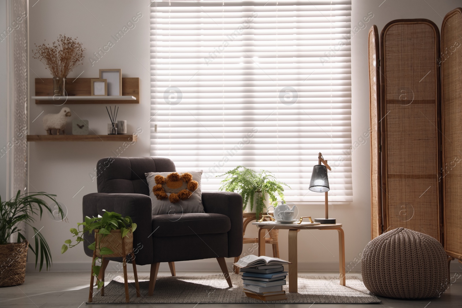 Photo of Comfortable place for rest with armchair near window in room