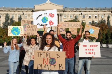 Photo of Group of people with posters protesting against climate change on city street