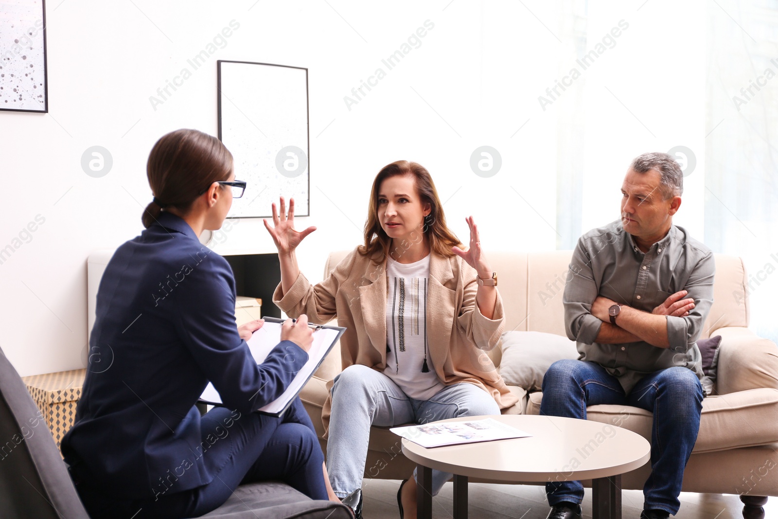 Photo of Psychotherapist working with couple in office. Family counselling