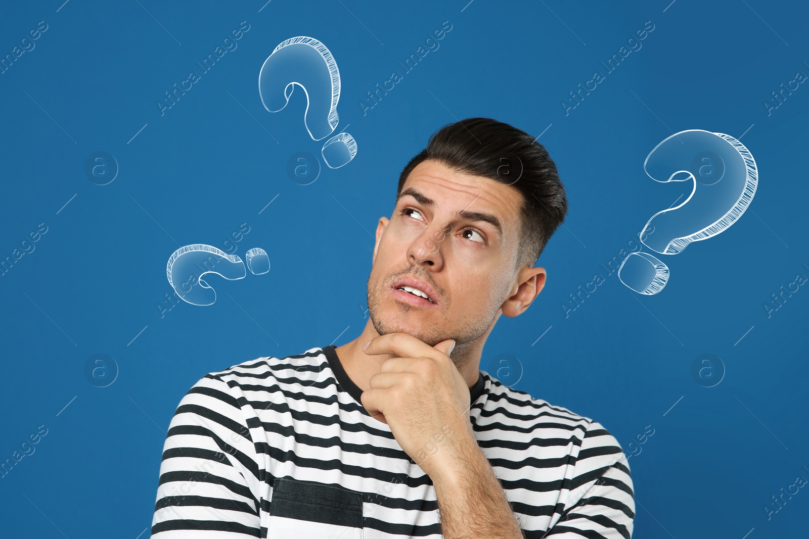 Image of Choice in profession or other areas of life, concept. Making decision, thoughtful man surrounded by drawn question marks on blue background