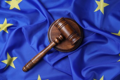 Photo of Wooden judge's gavel on flag of European Union, top view