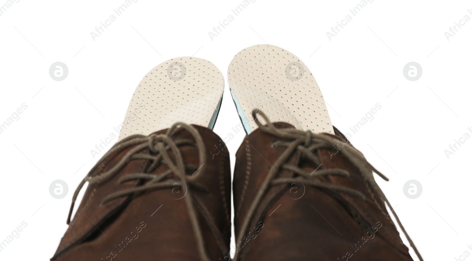 Photo of Orthopedic insoles in shoes on white background, closeup