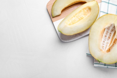 Photo of Pieces of delicious honeydew melon on white table, flat lay. Space for text