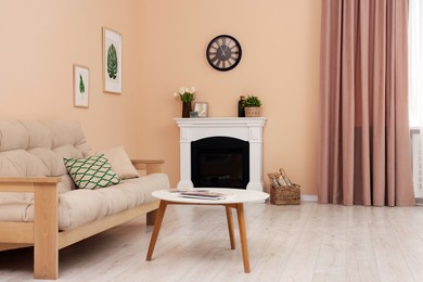 Photo of Stylish fireplace near comfortable sofa and coffee table in cosy living room