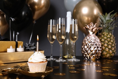 Photo of Cupcake with candle and blurred balloons on background