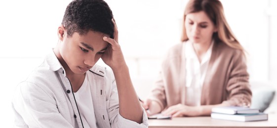 Image of Young female psychologist working with teenage boy in office. Banner design