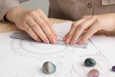 Photo of Astrologer calculating natal chart for making forecast of fate at table, closeup. Fortune telling