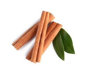 Cinnamon sticks and green leaves isolated on white, top view