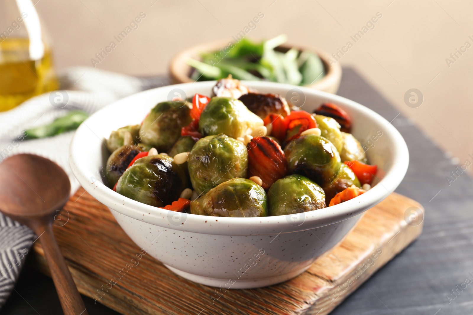 Photo of Bowl of warm salad with Brussels sprouts and carrots on table