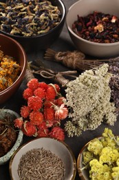 Many different dry herbs and flowers on dark grey table