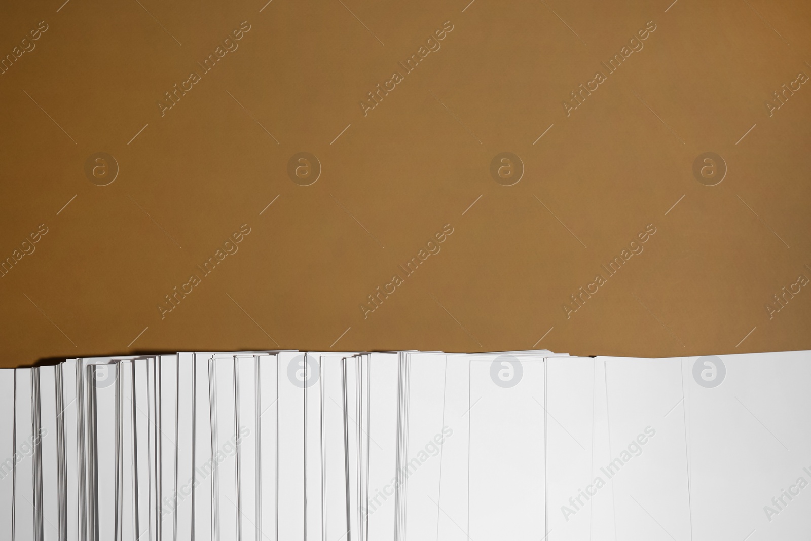 Photo of White paper sheets on brown background, flat lay. Space for text