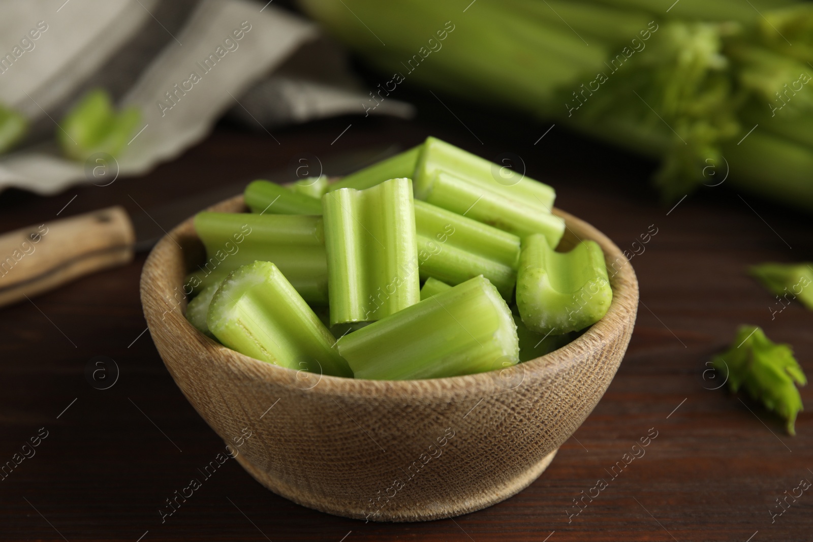 Photo of Cut celery in bowl on wooden table