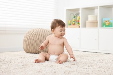 Photo of Cute baby boy sitting on carpet at home