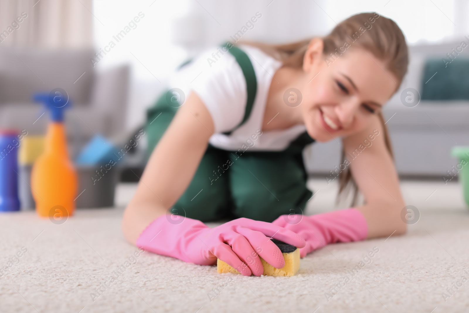 Photo of Female worker cleaning carpet at home