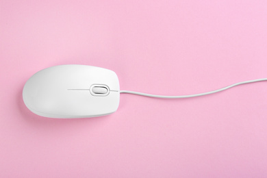 Modern wired optical mouse on pink background, top view