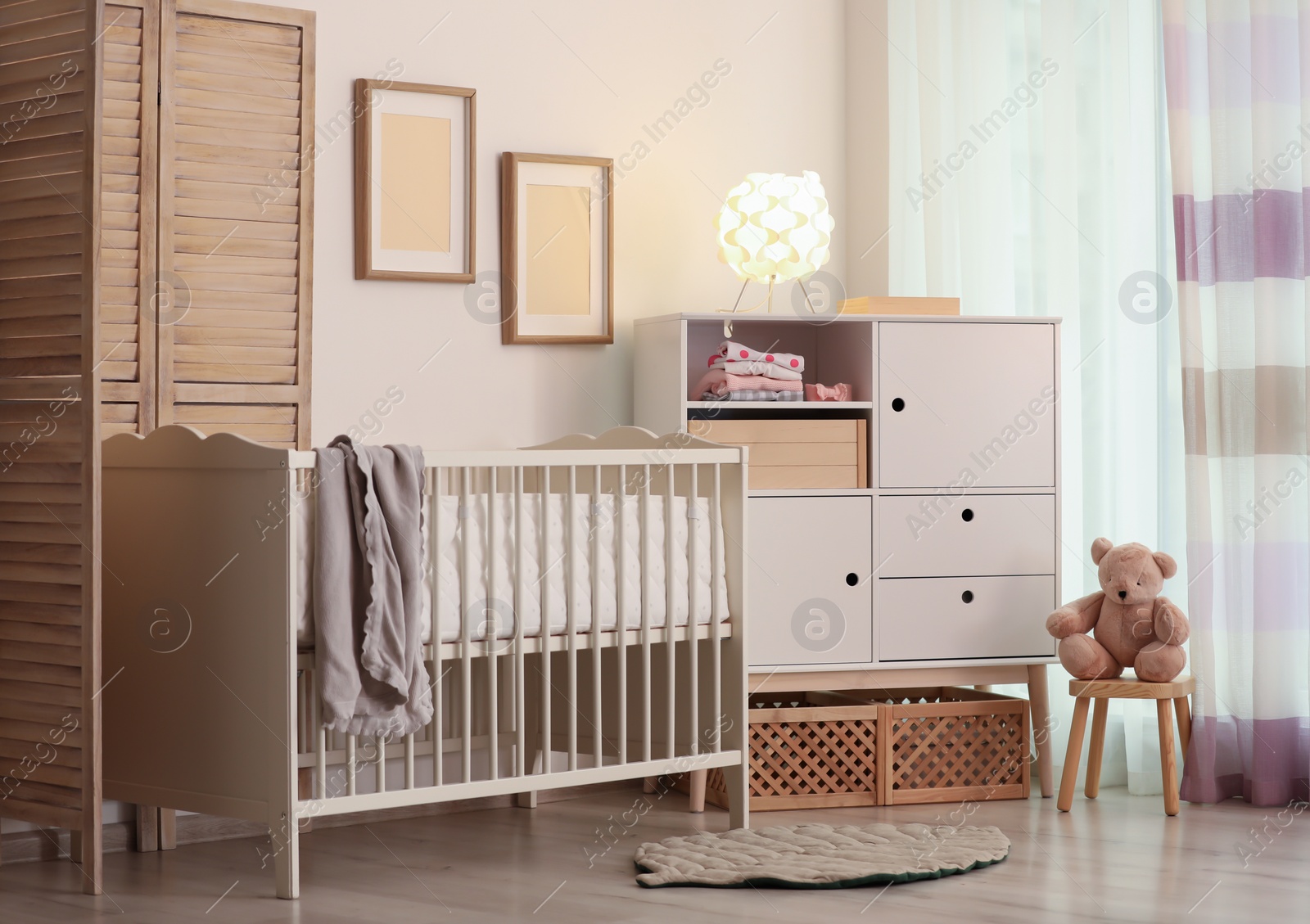 Photo of Modern room interior with crib and wooden crates under cupboard. Eco style