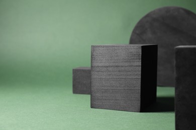 Black geometric figures on green background, space for text. Stylish presentation for product