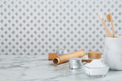 Photo of Tooth powder, brushes and jars on white marble table, space for text