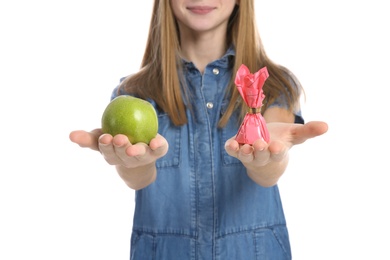 Photo of Teen girl with apple and candy on white background, closeup. Diabetes diet