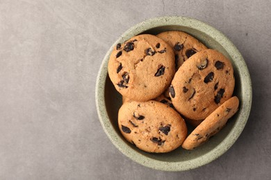 Photo of Delicious chocolate chip cookies on grey table, top view. Space for text