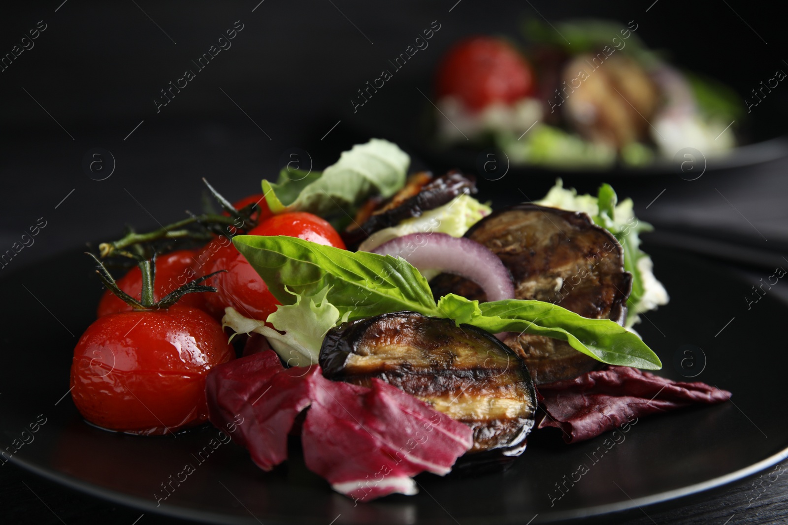 Photo of Delicious salad with roasted eggplant and basil on plate, closeup