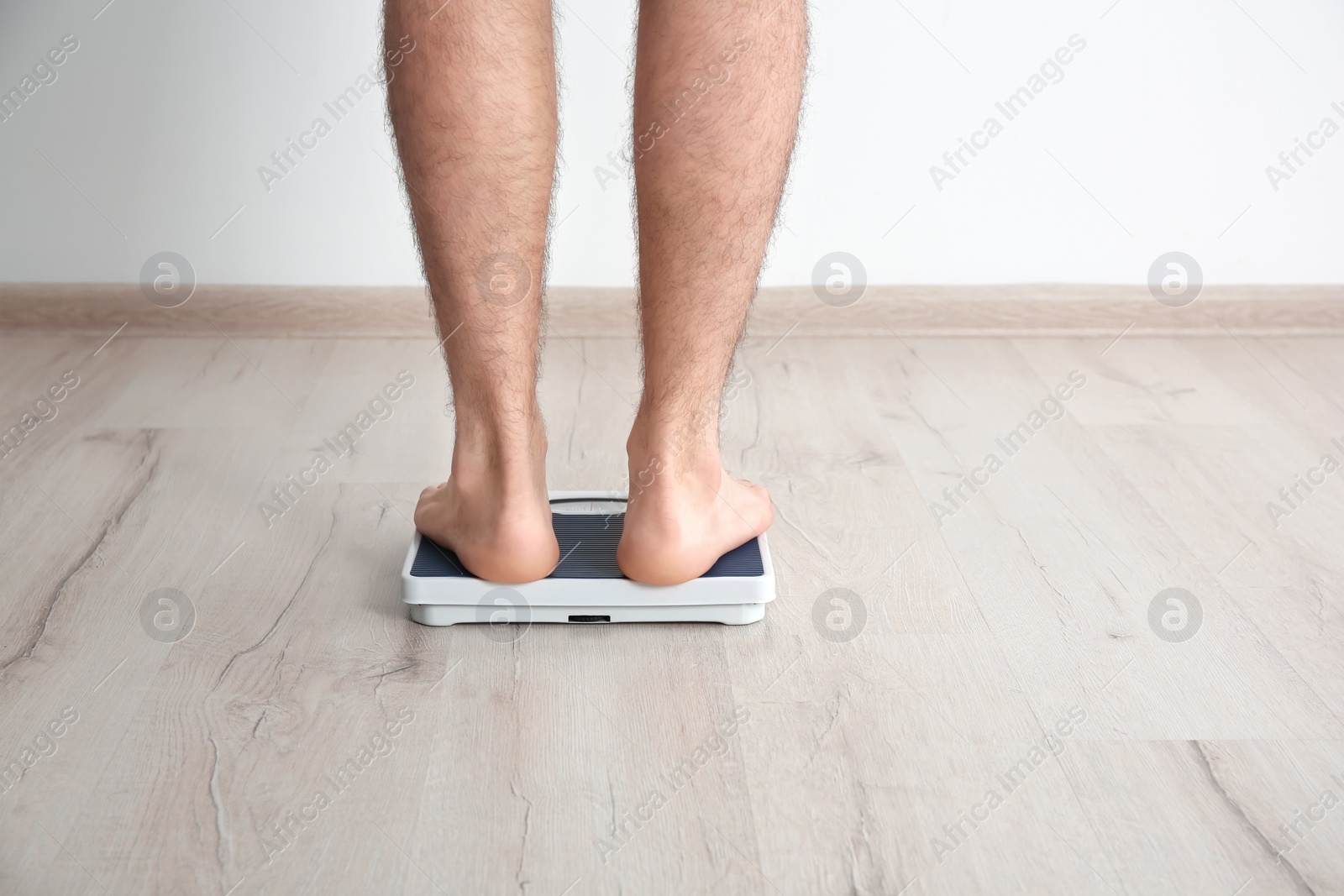 Photo of Overweight man measuring his weight indoors