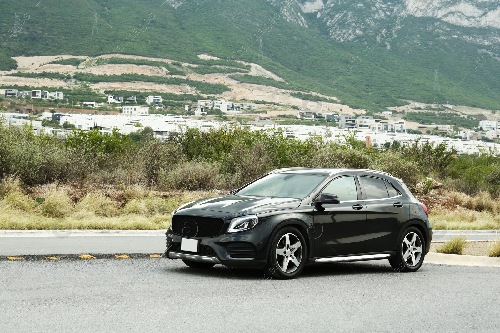 Photo of Beautiful modern black car on road near mountains