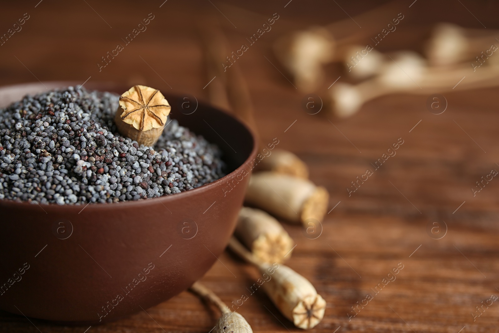 Photo of Bowl with poppy seeds on table, closeup