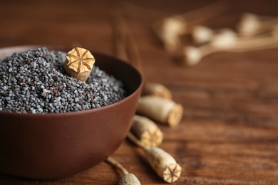 Photo of Bowl with poppy seeds on table, closeup