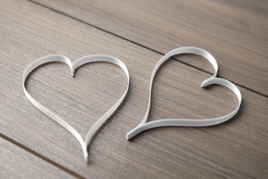 Hearts made of white ribbon on wooden background. Valentine's day celebration