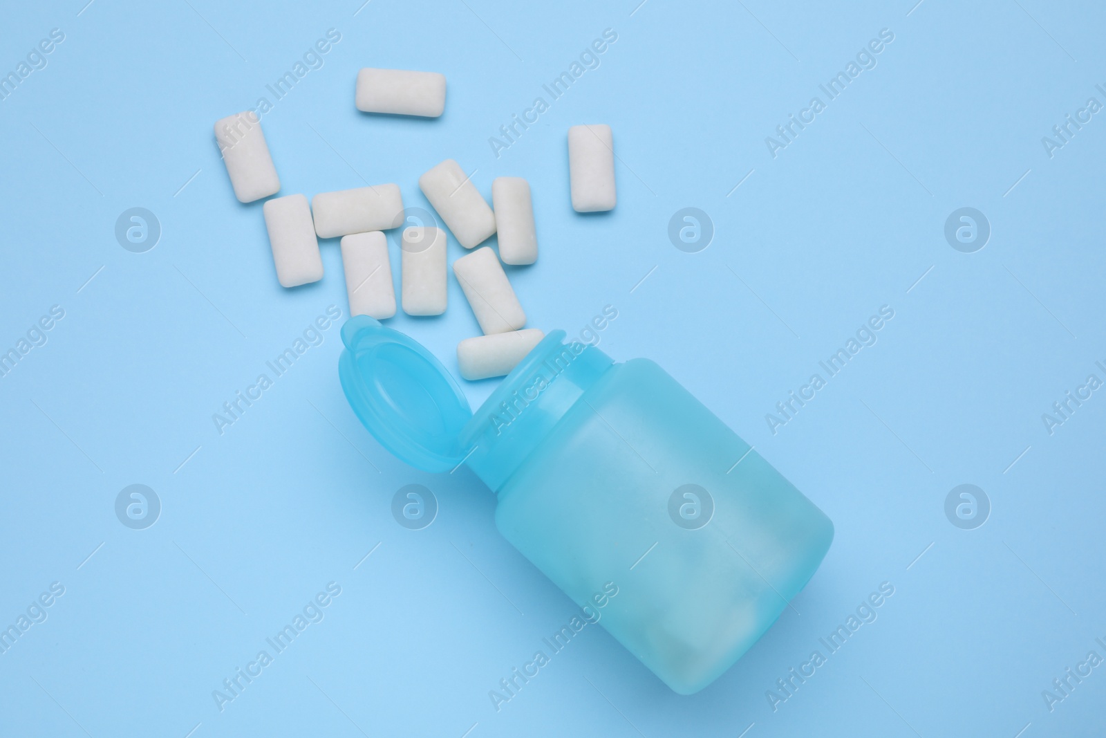 Photo of Jar with chewing gums on light blue background, flat lay