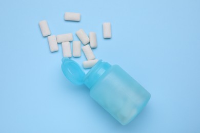 Jar with chewing gums on light blue background, flat lay