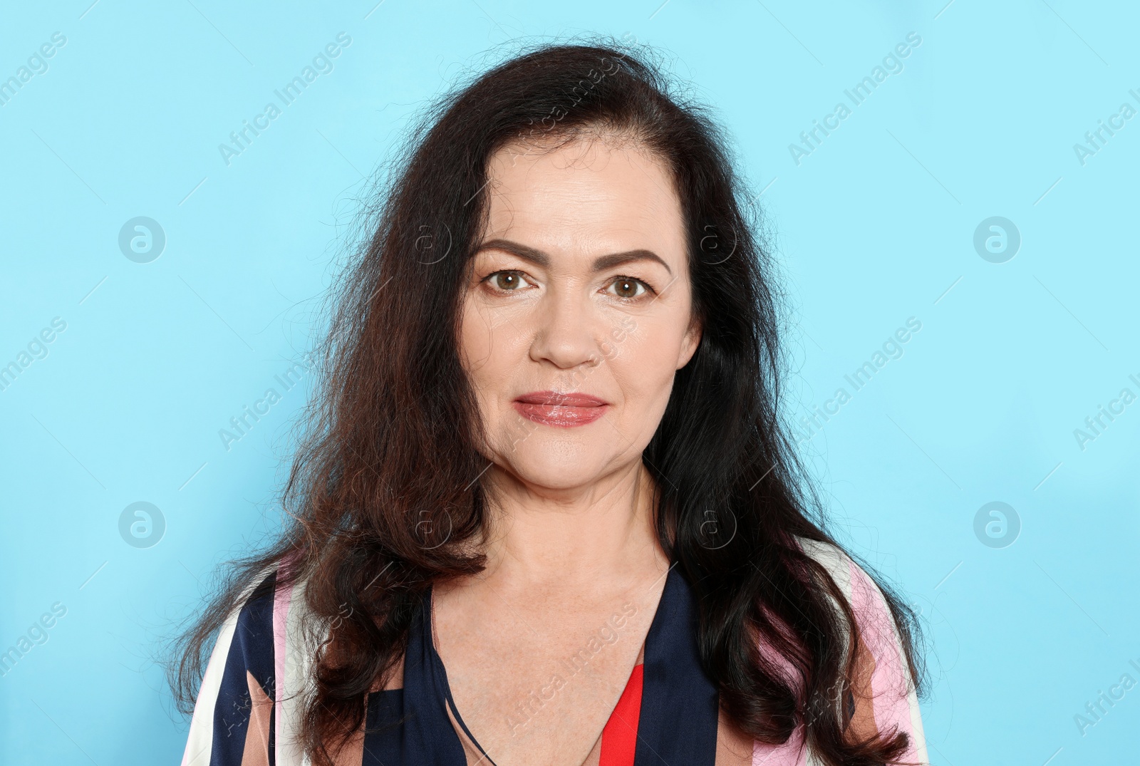 Photo of Portrait of mature woman with beautiful face on light blue background